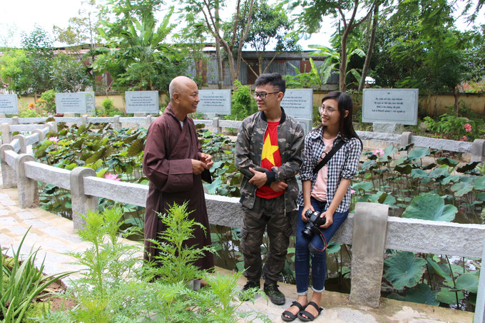 Thượng tọa Phước Cẩn đang giới thiệu vườn kinh A di đ&agrave; h&igrave;nh bản đồ Việt Nam với đầy đủ c&aacute;c quần đảo cho c&aacute;c bạn trẻ Ảnh: Nguy&ecirc;n Đạt/B&aacute;o Thanh Ni&ecirc;n