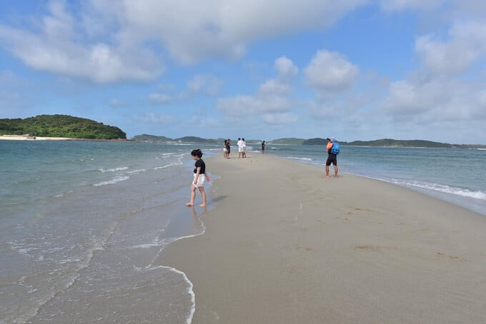 Du khách trải nghiệm đi bộ trên con đường cát giữa biển. Ảnh: Trần Văn Nam