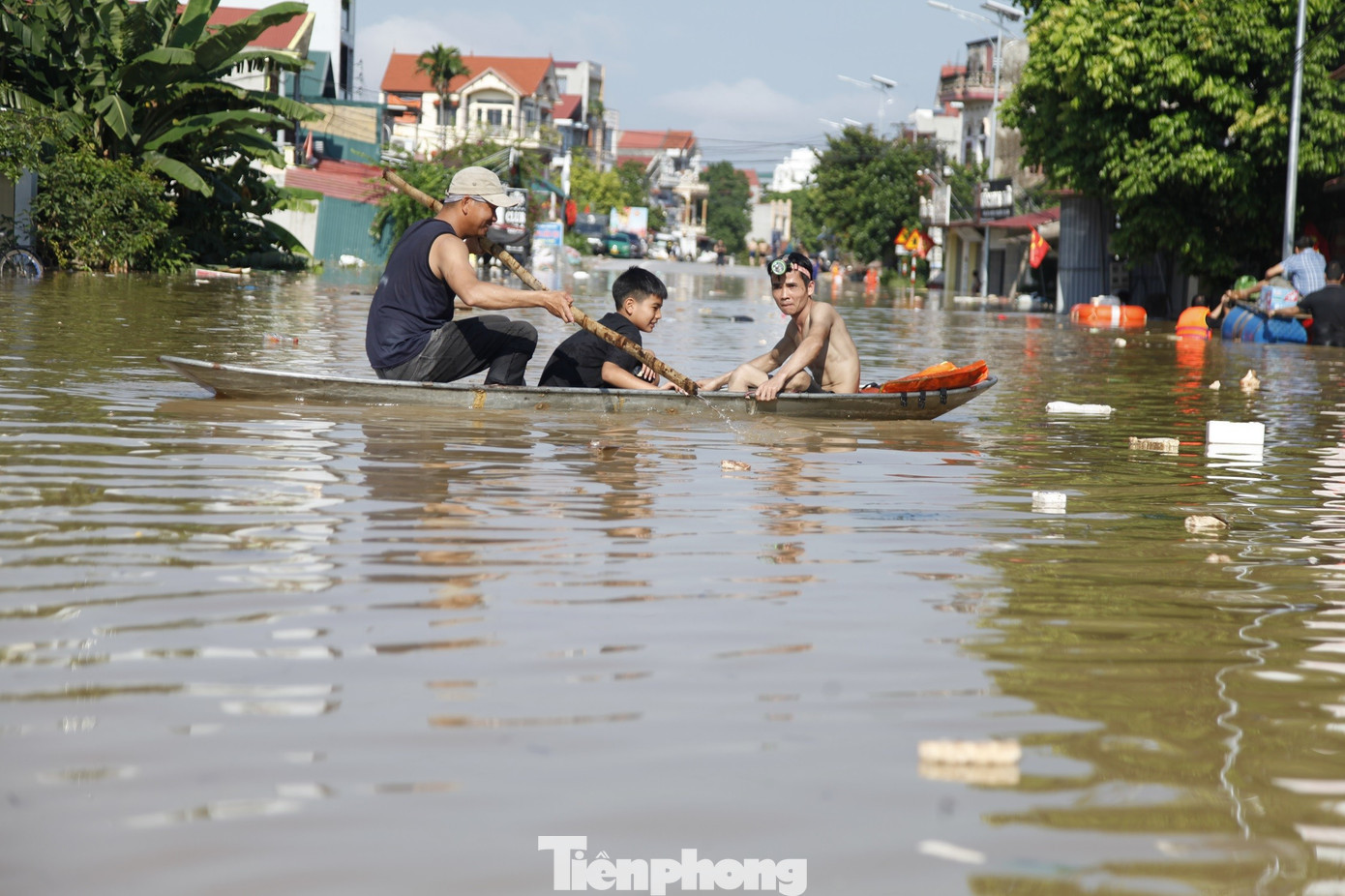Người dân dùng thuyền di chuyển qua đường bị ngập sâu. Ảnh: Nguyễn Thắng tp-13.jpg