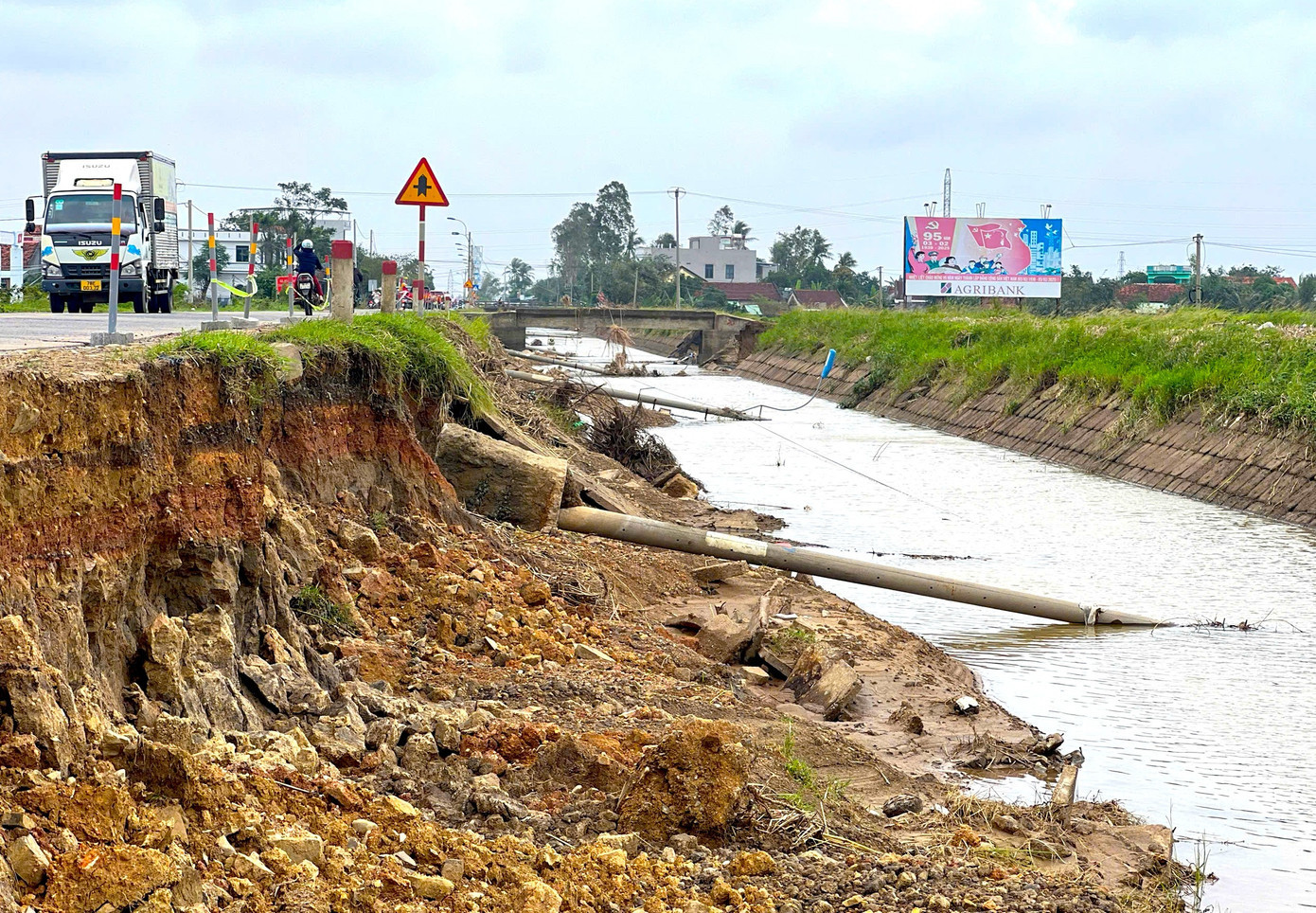 Hàng loạt cột điện dọc theo quốc lộ 29 bị xói mòn, đổ rạp về một phía từ Bắc vào Nam. 12.jpg