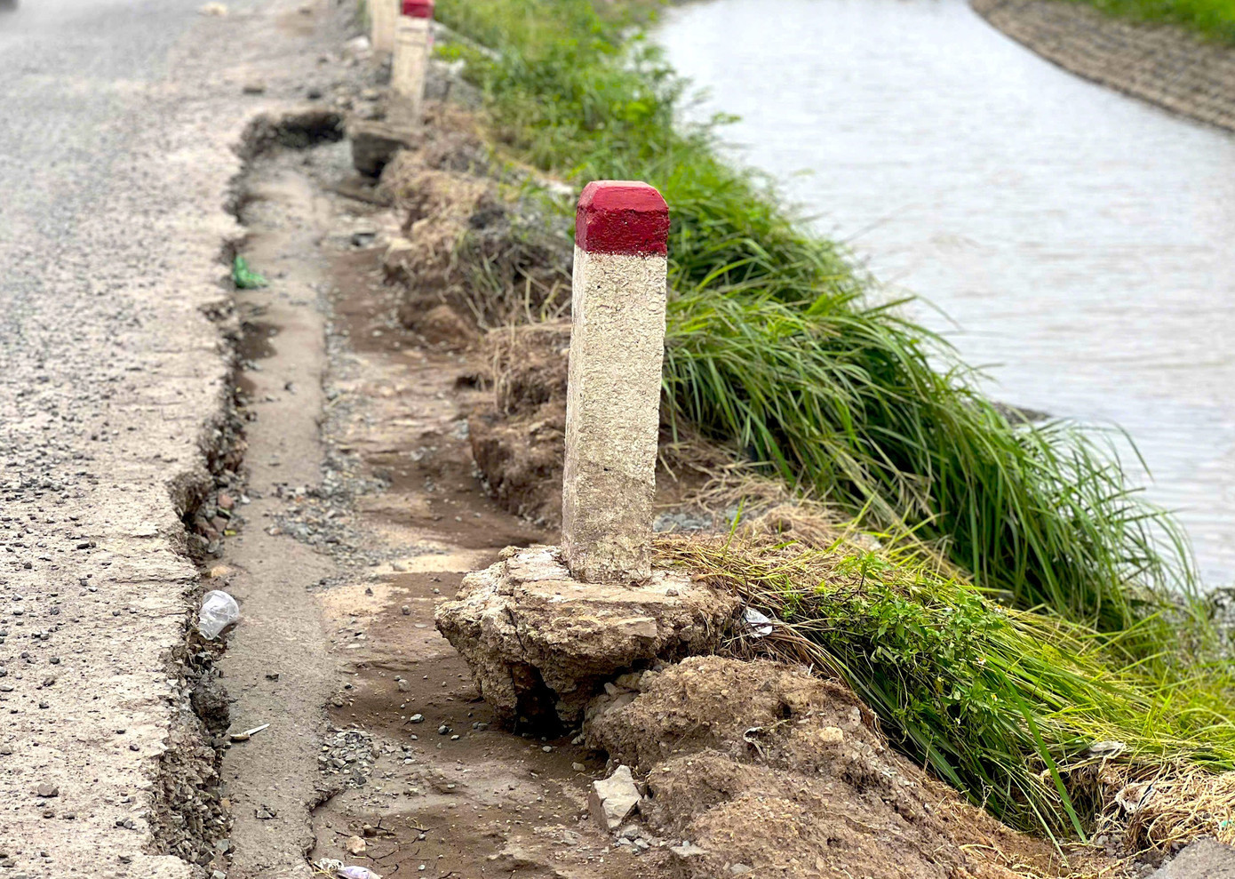 Các cột mốc dọc quốc lộ 29 bị xói mòn gốc. 16.jpg