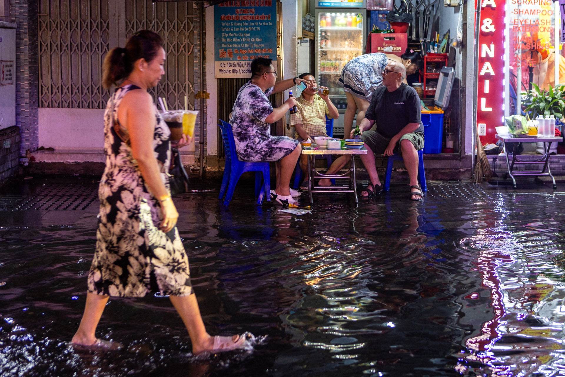 Nhóm du khách ngồi uống bia, vừa trò chuyện, vừa ngắm cảnh Phố Tây ngập sau cơn mưa. “Tôi không thích bị ướt. Nhưng khi mưa tạnh, tôi nhìn con đường rực sắc màu, hòa cùng âm nhạc sôi động xung quanh, mới thấy thật thú vị