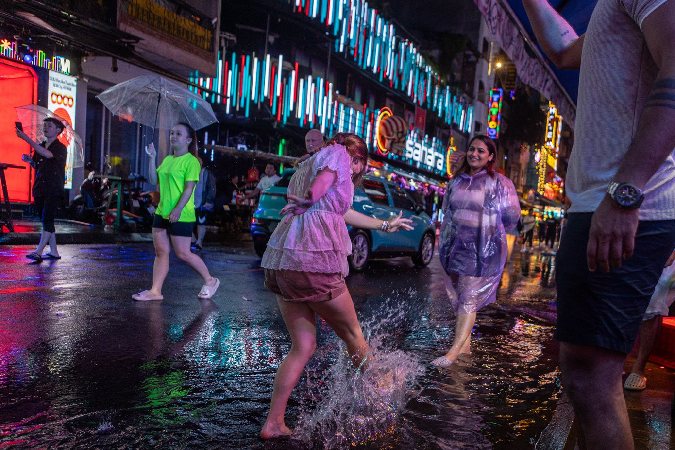 Cảnh tượng nước ngập ở Bùi Viện khiến nhiều du khách ngoại quốc tỏ ra thích thú. Từng nhóm người rủ nhau mặc áo mưa, lội nước đi dạo khắp phố đi bộ. Chị Amelia (26 tuổi, người Canada) hào hứng nghịch nước sau vài ngụm bia. 