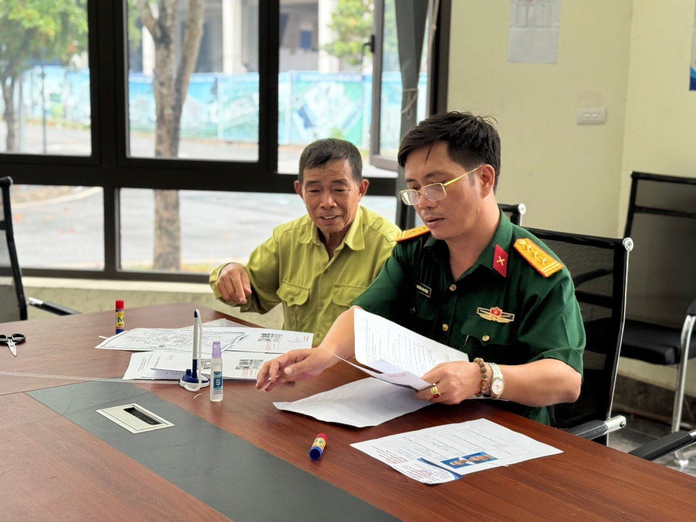 Thượng tá Nguyễn Văn Dũng, Phó Giám đốc Ban Quản lý các dự án đầu tư, Tổng Cty 319, hướng dẫn khách hàng là một thương binh làm thủ tục nộp hồ sơ nhà ở xã hội 10a.jpg