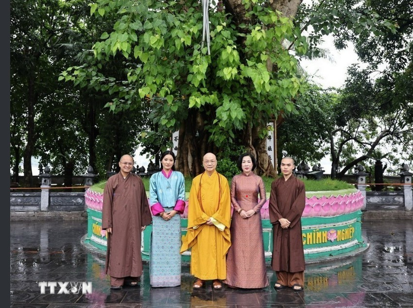 Phu nhân Nguyễn Thị Minh Nguyệt và Hoàng hậu Bhutan chụp ảnh cùng các nhà sư bên gốc cây bồ đề trong sân chùa Trấn Quốc. Ảnh: Nhật Minh phu-nhan-7.jpg