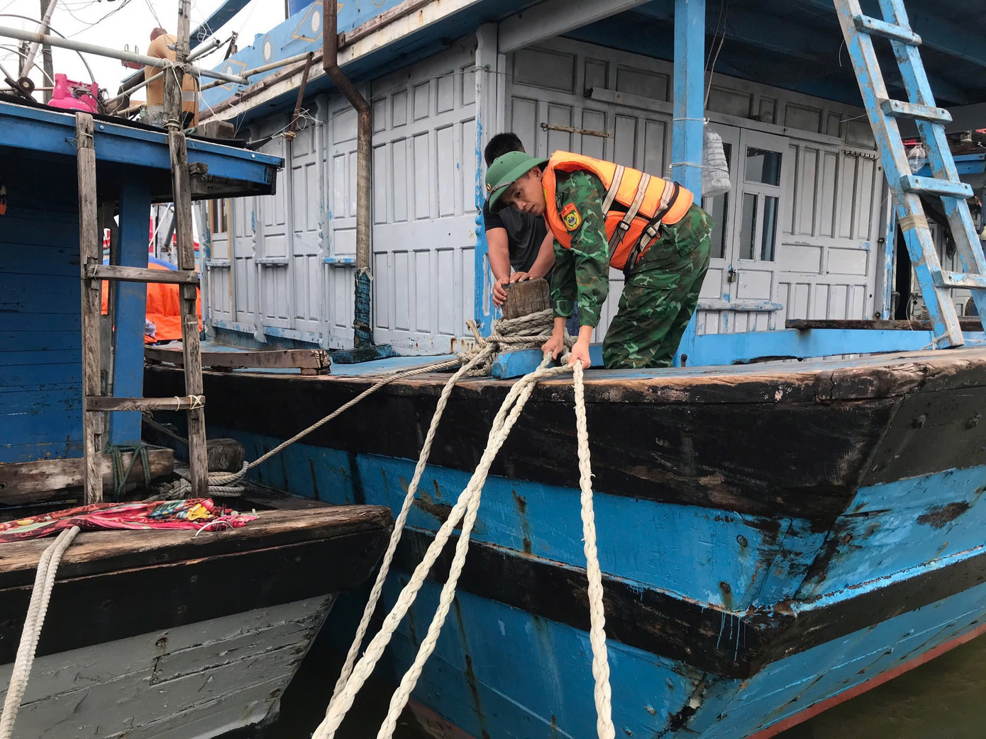 Lực lượng quân đội hỗ trợ ngư dân TP Huế chằng néo tàu thuyền sau khi phương tiện đánh bắt thủy sản được đưa vào bờ trú tránh bão . pcbaoso5-1.jpg