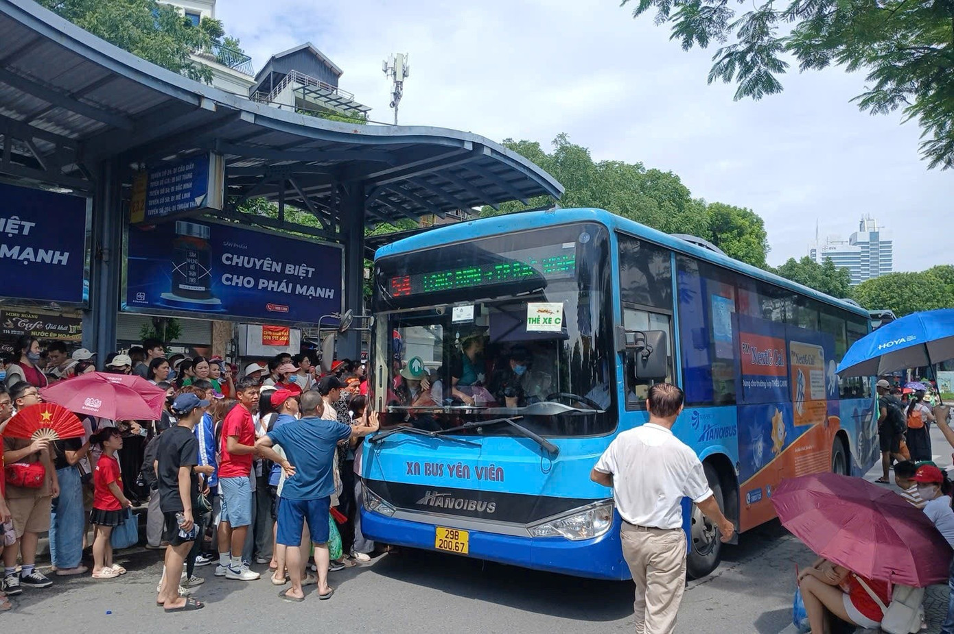 Trong sáng và trưa 30/8, tại nhiều điểm đón trả khách của xe buýt ở khu vực nội thành Hà Nội rất đông người dân đứng chờ, lên xe buýt. 1a.jpg