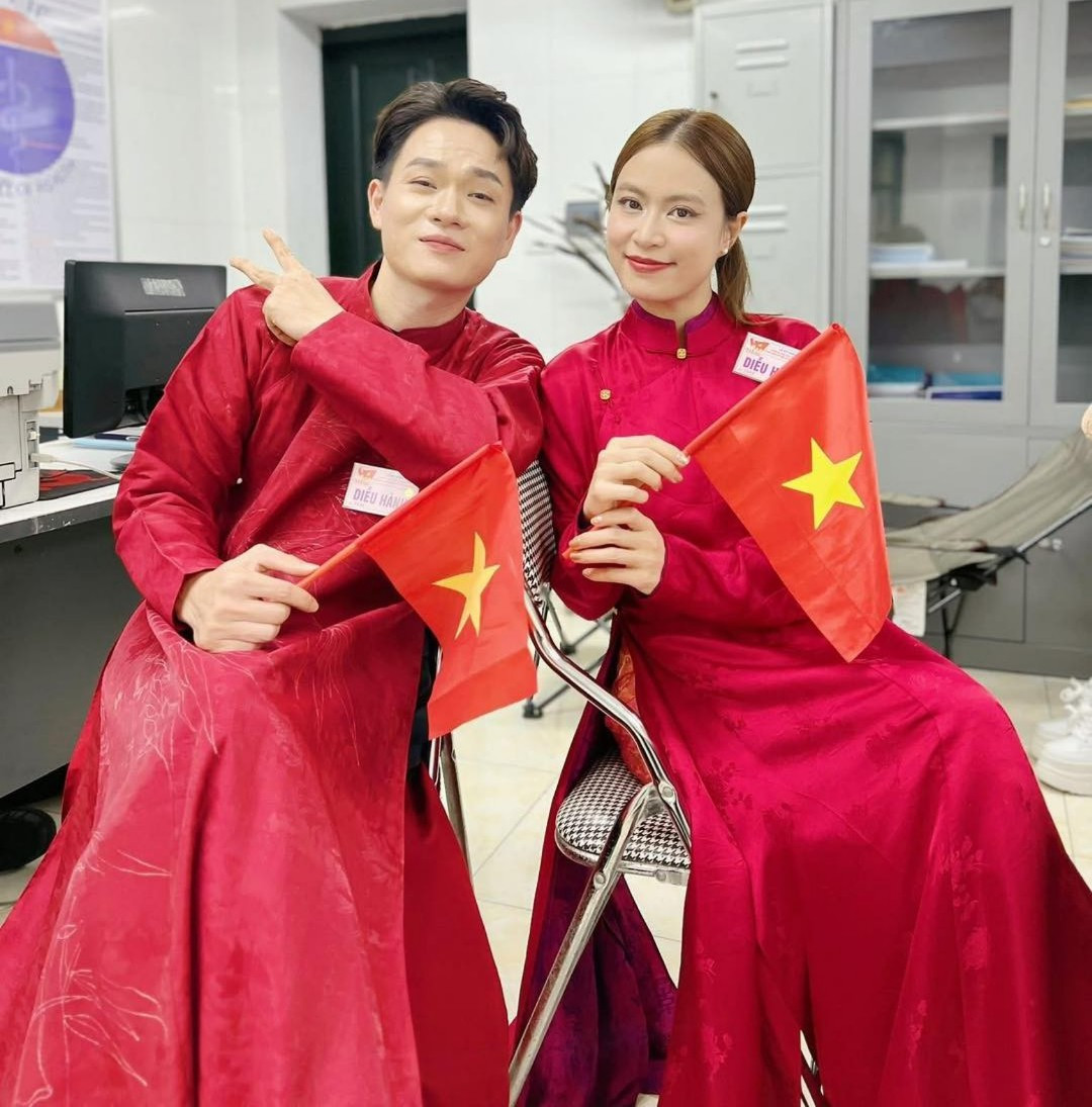 Hoàng Thùy Linh và đồng nghiệp diện áo dài đỏ rực, mang cờ nước chuẩn bị bước vào đội hình tổng duyệt. 540429652-766511265995191-369145205245189572-n-1774.jpg