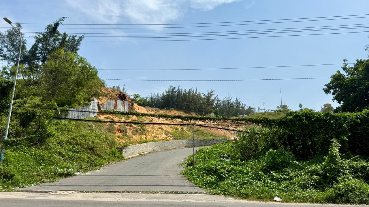 Đây là cổng vào của dự án Goldsand Hill Villa nằm tại đường Huỳnh Thúc Kháng, phường Mũi Né, tỉnh Lâm Đồng. Dự án có vị thế đắc địa nằm trên đồi, hướng nhìn ra biển nhưng cổng vào dự án không đề tên, dây điện chằng chịt, bị cây xanh bám đầy. z6876190320180-b28668509aed659f59984b08fa85ba92.jpg