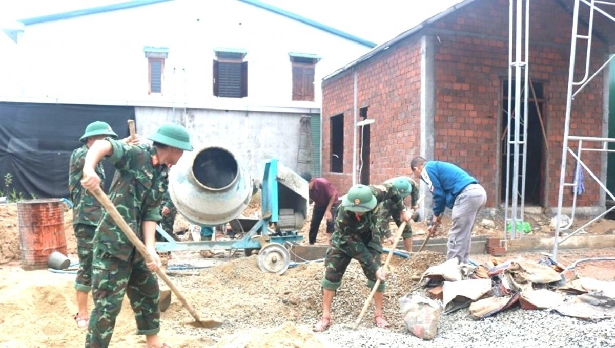 Cán bộ, chiến sĩ hỗ trợ xây dựng, sửa chữa nhà giúp người dân vùng thiên tai. Ảnh: VGP. 2126qtrung.jpg