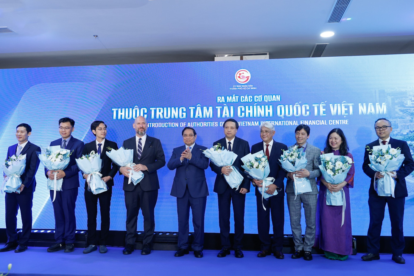 Thủ tướng Phạm Minh Chính tặng hoa cho đại diện các cơ quan thuộc Trung tâm Tài chính quốc tế Việt Nam. Ảnh: VGP/Nhật Bắc. img0026-1770780690070527230002.jpg