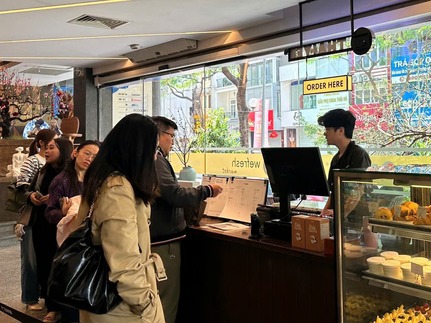 Khách xếp hàng chờ tới lượt gọi đồ tại quán cafe. Trong dịp cao điểm Tết Nguyên đán, rất nhiều quán cafe tại khu vực trung tâm Thủ đô đã mở cửa trở lại. Một số nơi dành tặng lì xì may mắn, voucher giảm giá cho khách hàng. z7548464141983-b40c25c95d8542ed1a253f10ebd3d59d.jpg