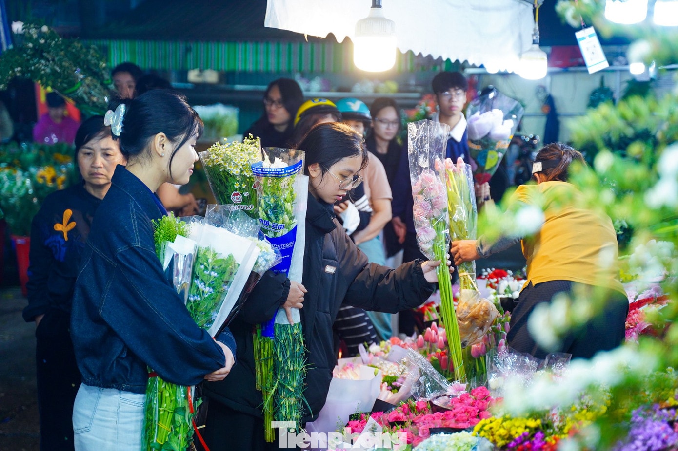 Bạn Chu Thủy (áo đen, đang lựa hoa) chia sẻ: “Tôi và bạn thân mang khoảng 2 triệu đồng đến chợ nhập hoa về bán thử. Hai đứa dự định bày bán ở khu vực vỉa hè quanh hồ Tây, hy vọng kiếm thêm chút tiền và có thêm trải nghiệm kinh doanh”. tp-d20.jpg