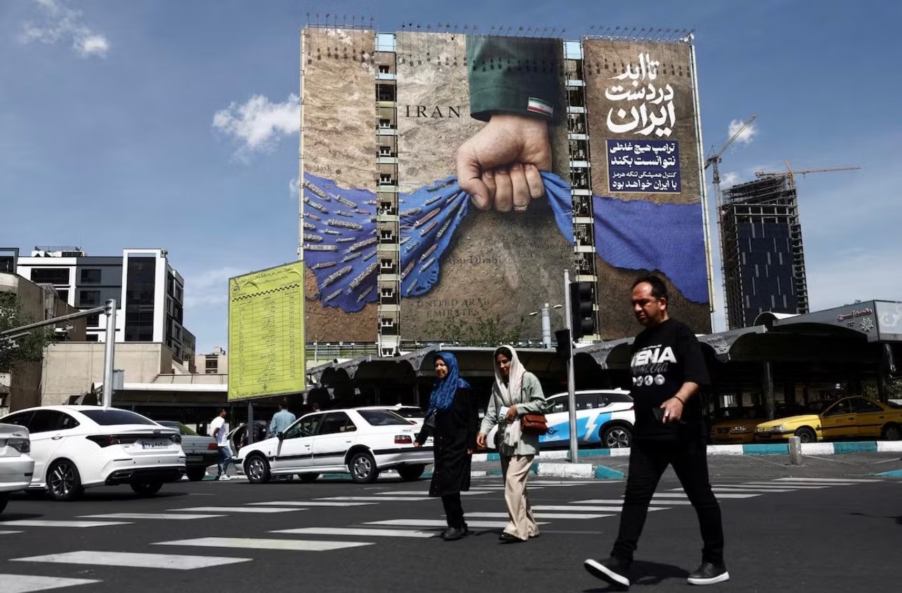 Tấm áp phích ở trung tâm thủ đô Tehran của Iran mô tả tình hình eo biển Hormuz. (Ảnh: Reuters) Mỹ xem xét đề xuất mới của Iran, lo ngại chiến thuật câu giờ - Ảnh 1.