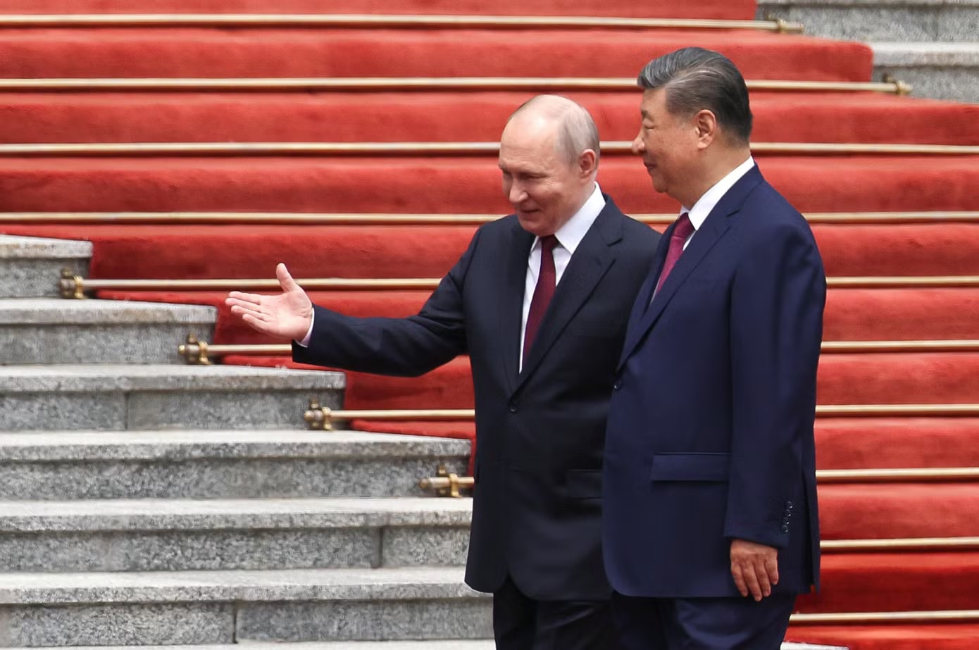 Hai lãnh đạo tươi cười bắt tay trên thảm đỏ, sau đó chào hỏi phái đoàn hai nước. (Ảnh: Reuters) Lễ đón chính thức Tổng thống Nga Vladimir Putin tại Trung Quốc - Ảnh 2.