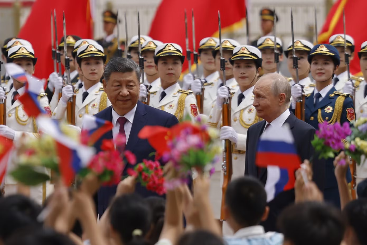 Các em nhỏ vẫy cờ Nga và Trung Quốc chào đón Tổng thống Nga Putin. (Ảnh: Reuters) Lễ đón chính thức Tổng thống Nga Vladimir Putin tại Trung Quốc - Ảnh 9.