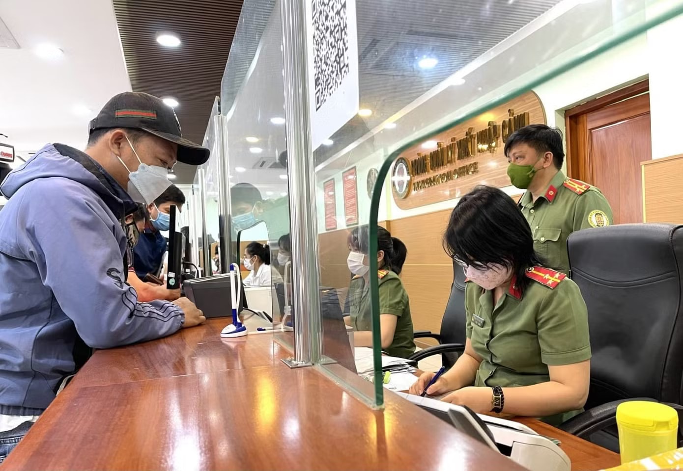 Người dân làm thủ tục ở phòng xuất nhập cảnh. Ảnh minh họa: <a style='text-decoration: none;' href='/ACC'>ACC</a> Làm gì để không bị hoãn xuất cảnh vì nợ thuế? - Ảnh 1.