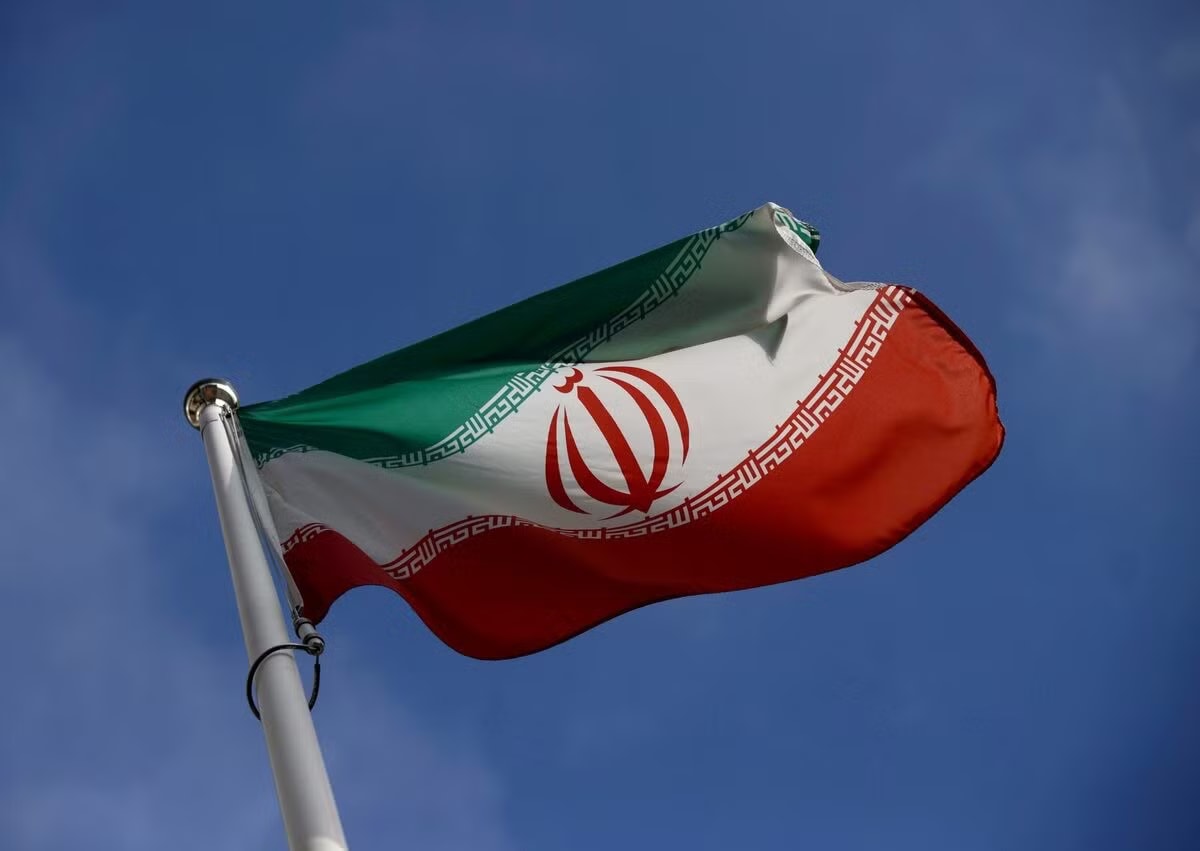 Lá cờ Iran tung bay trước trụ sở Cơ quan Năng lượng Nguyên tử Quốc tế (IAEA). (Ảnh: Reuters) Iran đồng ý từ bỏ kho dự trữ uranium làm giàu? - Ảnh 1.