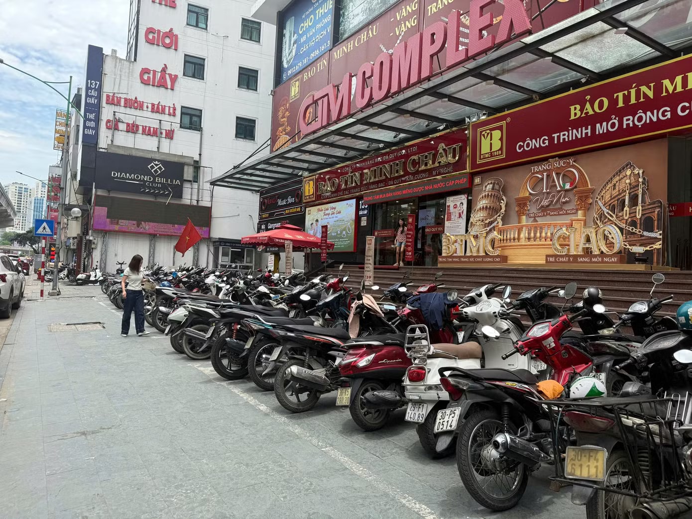 Chỗ để xe cửa hàng vàng trên phố Cầu Giấy (Hà Nội) kín chỗ khách (ảnh: Ngọc Mai). Lỗ ngay 4 triệu đồng/lượng, vì sao nhiều người vẫn xếp hàng mua vàng? - Ảnh 1.