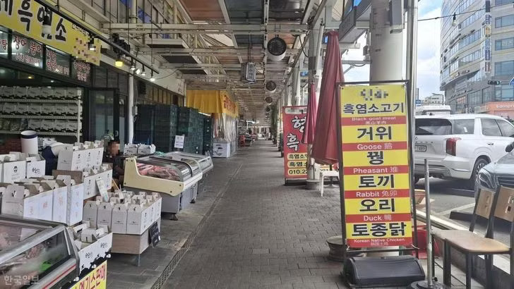 Nhiều người chuyển từ kinh doanh thịt chó sang bán các món ăn từ thịt dê đen tại chợ Moran ở Seongnam, tỉnh Gyeonggi. Ảnh: Korea Times. Cảnh tượng chợ thịt chó nổi tiếng Hàn Quốc trước 'án tử' - Ảnh 1.