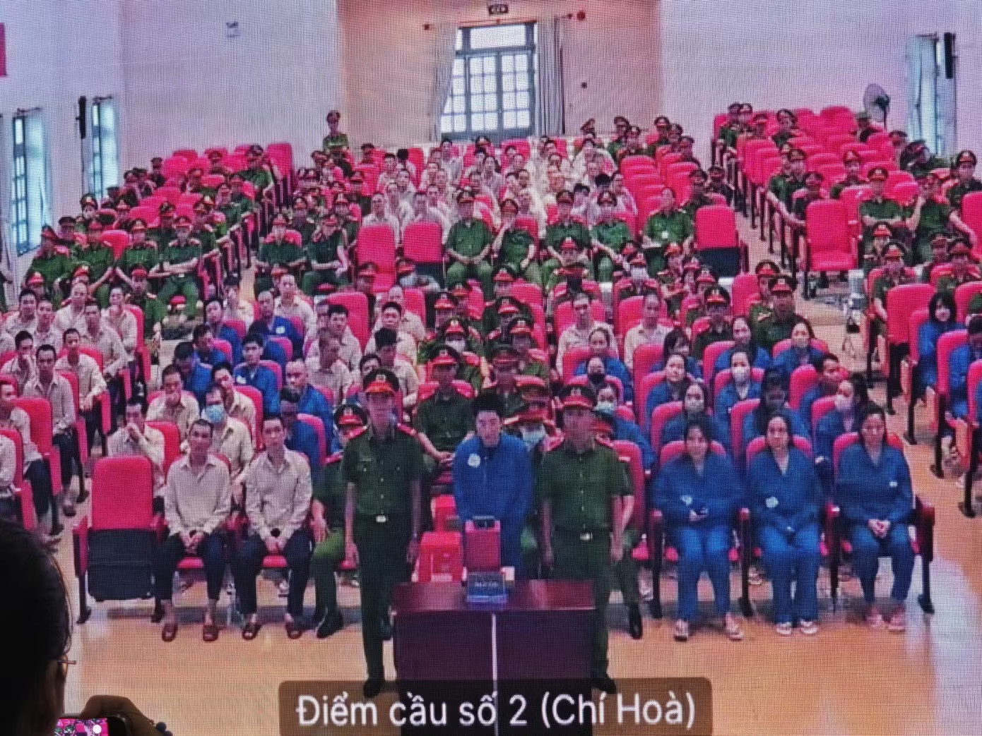 Ca sĩ Chi Dân tại phiên tòa, Ảnh chụp qua màn hình. Đại án VN10: Chi tiết mức án đề nghị đối với ca sĩ Chi Dân, người mẫu An Tây và 'Cô tiên từ thiện' - Ảnh 2.