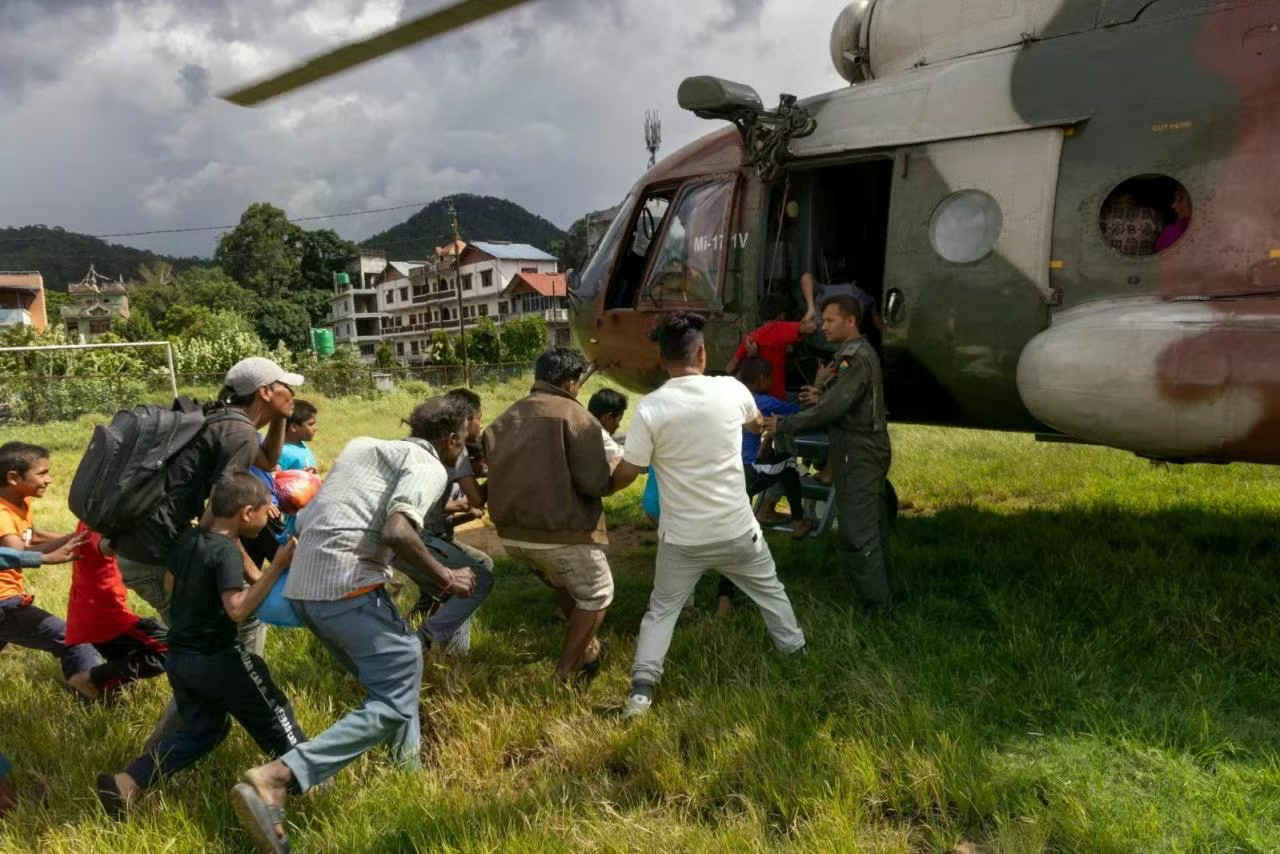 Trực thăng của lực lượng an ninh Nepal sơ tán người dân từ khu vực Nuwakot. (Ảnh: Reuters) Hậu lũ quét, Nepal chôn cất tập thể hàng trăm nạn nhân chưa rõ danh tính - Ảnh 1.